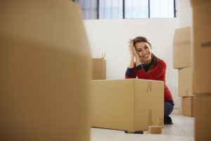 Mujer feliz sonriendo en casa durante la mudanza con cajas